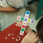 a young girl is holding a cross made of paper